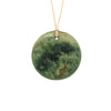 Disc Pounamu (Greenstone) pendant by Ric Moor on an adjustable cord against a white background