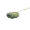 Disc Pounamu (Greenstone) pendant by Ric Moor on an adjustable cord against a white background